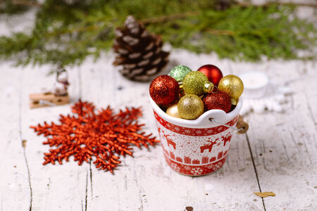 Porcelain bucket with red deer ornament full of colorful baubles for Christmas and New Year decoration with greeting cardの写真素材