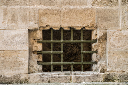 Green lattice with a hole in the window in the old town