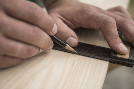 The joiner marks the workpiece with a pencil. joinery. carpenter. woodworkerの写真素材
