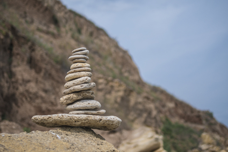 balancing pyramid of stones on a large stone on the seashoreの写真素材