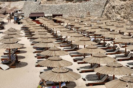 Beach with sun loungers and umbrellasの写真素材