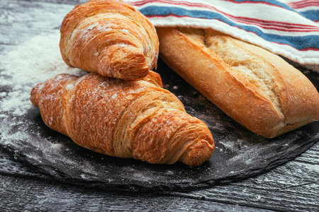 Croissants, baguette. Croissants are fresh on a white wooden background. French cuisine