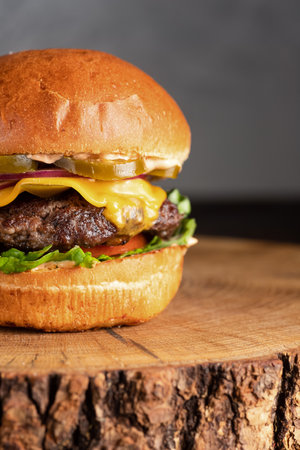 burger with meat, burger on a wooden table, juicy burger with different fillingsの写真素材