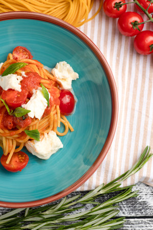 Pasta with tomatoes, pasta on a white wooden background, top viewの写真素材