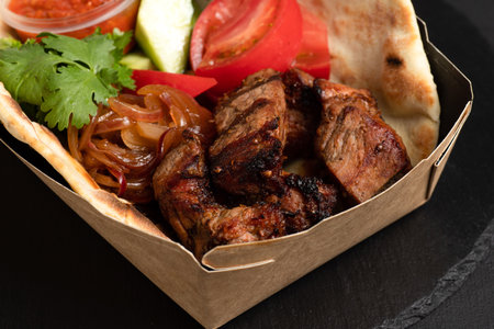 Barbecue with you, barbecue in a container with you on a black background, side viewの写真素材