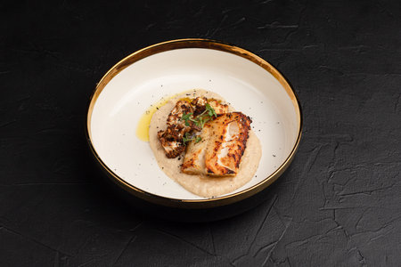 mashed fish, fried fish on a black background side view