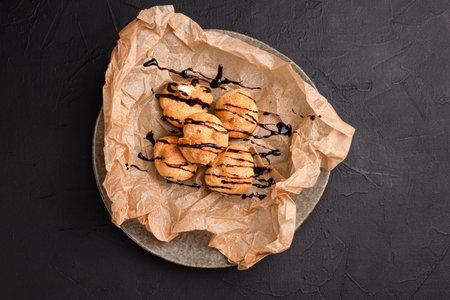 Profiteroles, profiteroles with chocolate and topping black background