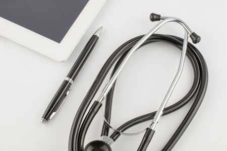 Tablet PC, stethoscope and pen on white background medical conceptの写真素材