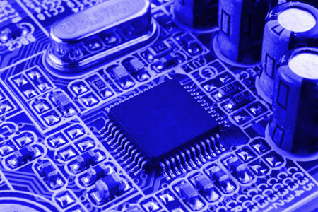 Chip on motherboard mainboard with controllers, ports and wires, close-up macro toned.