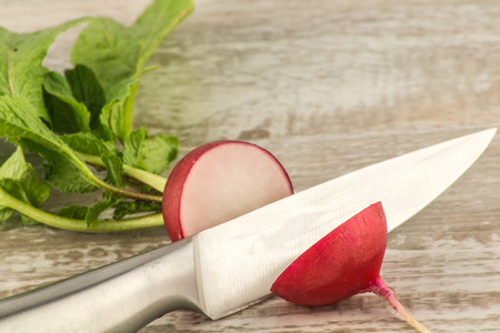 Juicy fresh radish in a cut on a white wooden background close up.の写真素材