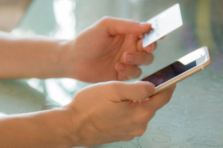 Internet banking in female hands against the background of a glass table.