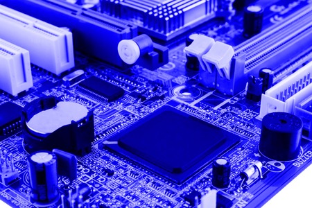 Integrated semiconductor microchip on blue circuit board representative of the high tech industry and computer science.の写真素材