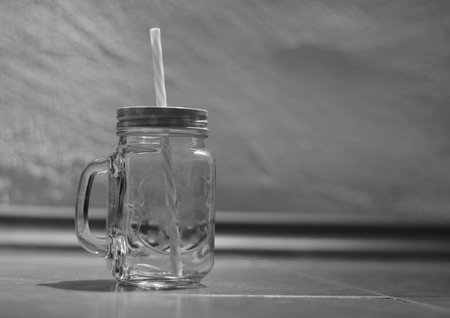 empty glass mug with straw wall background, black and whiteの写真素材