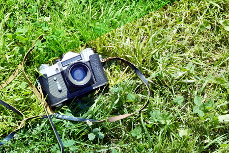 The film camera lies on the grass with the object to the sky in green tones.の写真素材