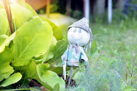 Funny garden gnome standing among nice flowers.の写真素材