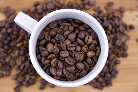 Cup of coffee full of coffee beans.の写真素材