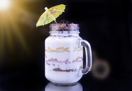 Dessert on a black background with an umbrella with a yellow highlight.の写真素材