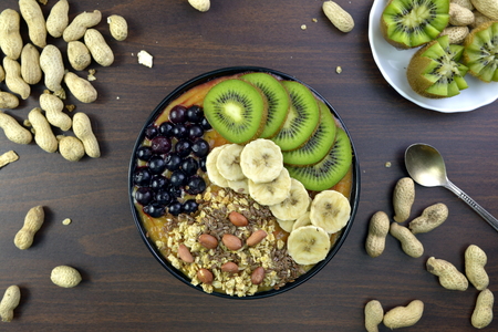 Breakfast with muesli, acai blueberry smoothie, fruits on brown background. Healthy food concept. Flat lay, top vie.の写真素材