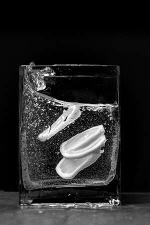 lemon in a cut in water in a glass on a black backgroundの写真素材