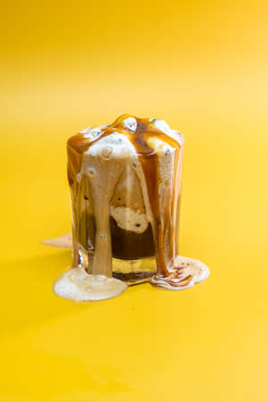 coffee drink with delicate jam and flowing foam on a yellow backgroundの写真素材