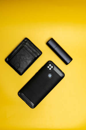 smartphone leather wallet and electronic cigarette on yellow backgroundの写真素材