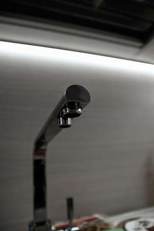 mixer pipe sink metal kitchen with lighting on gray backgroundの写真素材