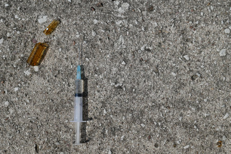ampoule with injection and syringe on gray stone background
