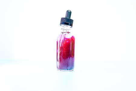 glass flask with purple paint on white backgroundの写真素材