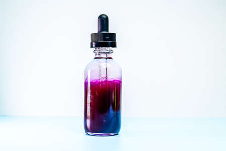 glass flask with purple paint on white backgroundの写真素材