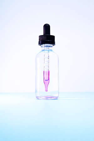 glass flask with purple paint on white backgroundの写真素材