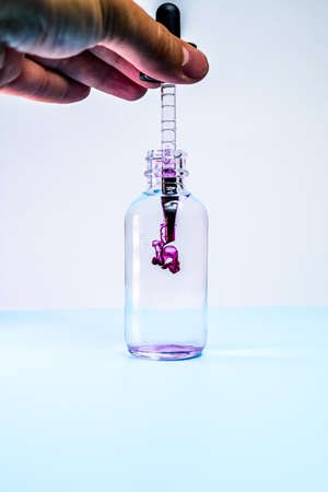 glass flask with purple paint on white backgroundの写真素材