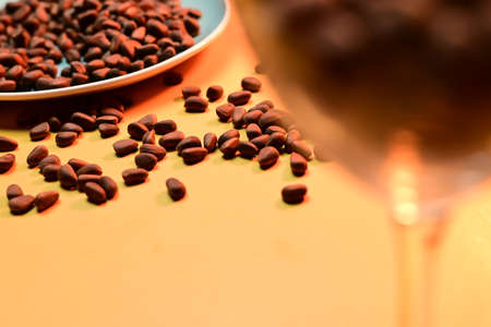 pine nuts scattered on a plate on a yellow backgroundの写真素材