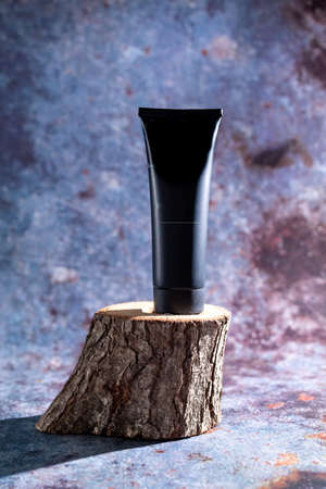 black tube on a wooden stand on a blue backgroundの写真素材