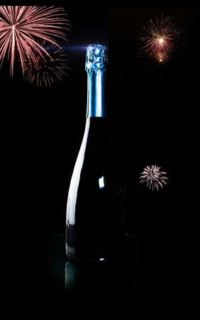 bottle of champagne on a black handicap with fireworksの写真素材