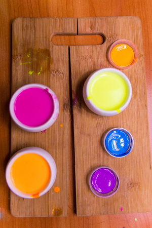 palette with blue, red, pink paint on a wooden base