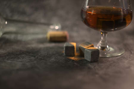 transparent whiskey with a bottle and a wooden cork on a dark background. whiskey stones in a glassの写真素材