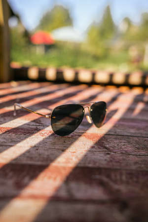 sunglasses for shops on a red wooden background with rays of lightの写真素材