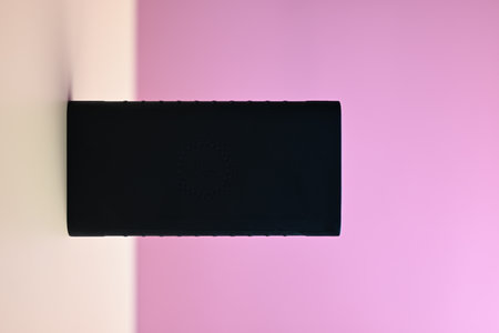 black battery for smartphone on orange and pink backgroundの写真素材