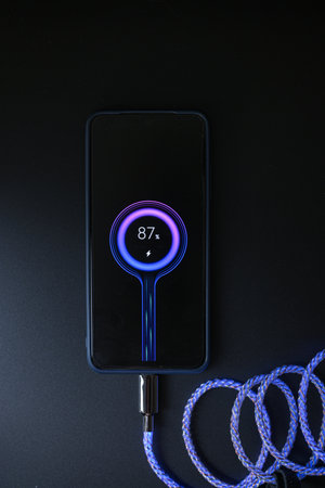 smartphone charging on LEDs on a black backgroundの写真素材