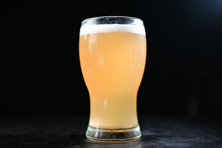 glass of beer on a dark table table on a dark backgroundの写真素材