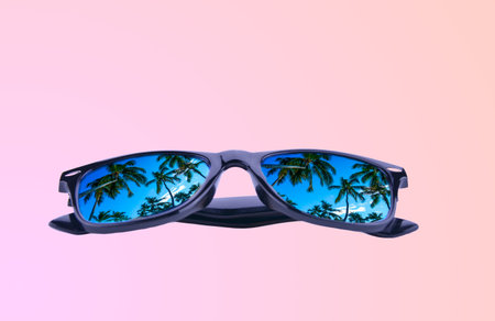 sunglasses with palm trees in reflection on a gradient beige backgroundの写真素材
