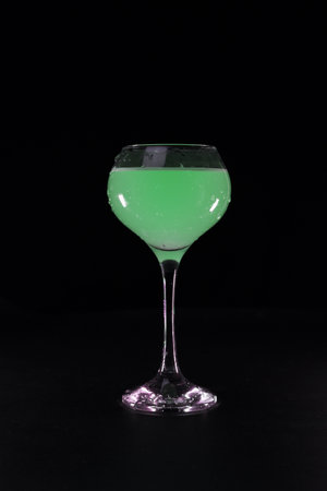glass with green cocktail on black backgroundの写真素材
