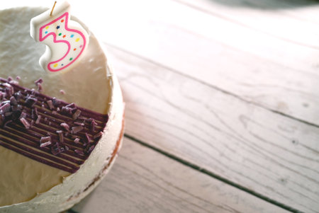 creamy birthday cake on light wooden backgroundの写真素材