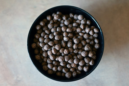 A bowl of chocolate balls for breakfast on a white backgroundの写真素材