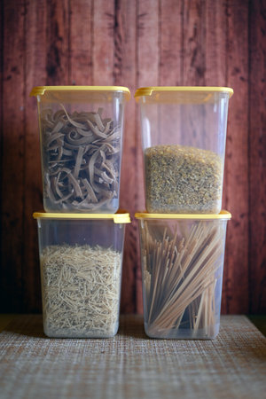 Containers for cereals with pasta, bulgur, rice on a wooden backgroundの写真素材