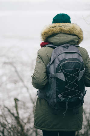A young man in camouflage and a backpack in the mountainsの写真素材