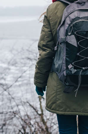 A young man in camouflage and a backpack in the mountainsの写真素材