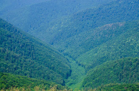 A young man in camouflage and a backpack in the mountainsの写真素材