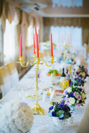 Festive table decorated with bouquets of roses and candlesの写真素材