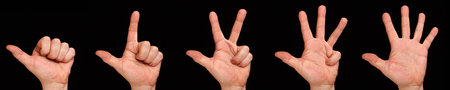 Counting fingers. Mans hand with the fingers of one to five on a black background.の写真素材